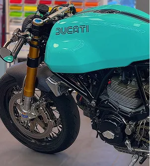 Moto Ducati turquoise personnalisée avec des accents dorés et noirs, vue de côté à Maisons-Laffitte dans les Yvelines 78