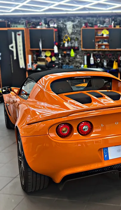 Lotus Elise orange dans un garage bien rangé avec des outils à Maisons-Laffitte dans les Yvelines 78