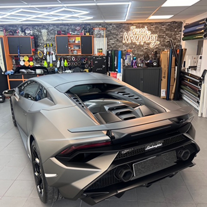 Lamborghini gris mat dans un garage de personnalisation, outils et vinyles visibles à Maisons-Laffitte dans les Yvelines 78