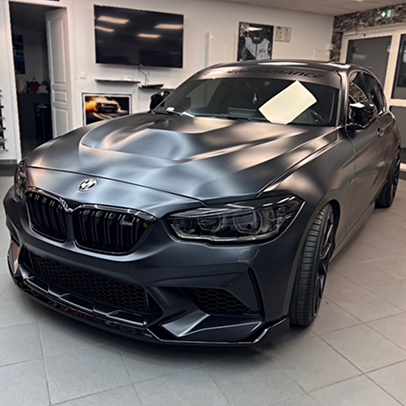 Arrière d'une Tesla Model 3 bleu satiné dans un atelier de wrapping.