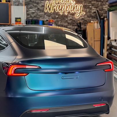 Moto Ducati turquoise avec des échappements doubles, une Lamborghini grise en arrière-plan.