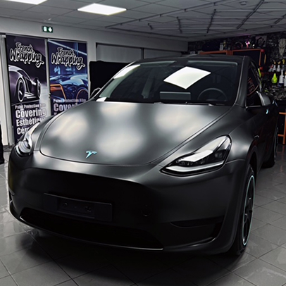 Tesla Model Y noire mate garée à l'intérieur d'un garage.