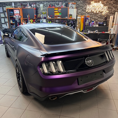 Voiture Volkswagen Golf rouge mat dans un atelier de wrapping.