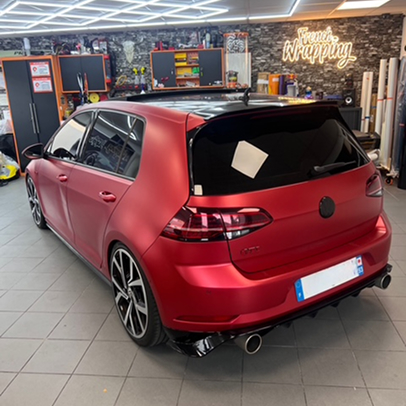 Porsche Macan gris mat avec étriers de frein rouges dans un garage éclairé.