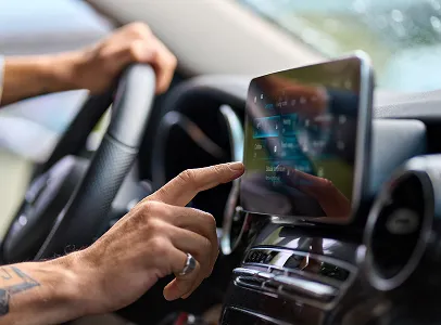 Main d'homme naviguant sur l'écran tactile du système d'infodivertissement d'une voiture à Maisons-Laffitte dans les Yvelines 78